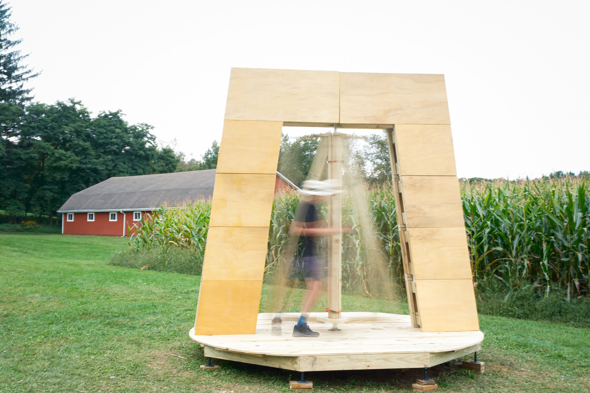A person spinning the vane inside the frame, motion-blurred, seen from the front in daylight